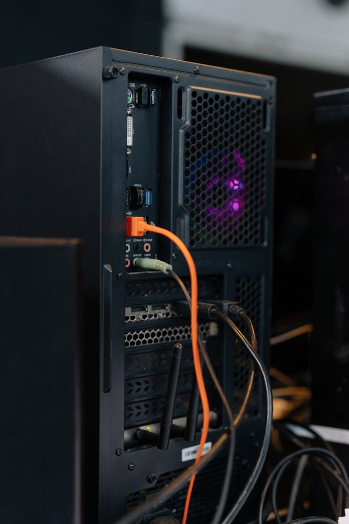 Services-03 Close-up of a desktop computer tower with connected cables and internal lighting.