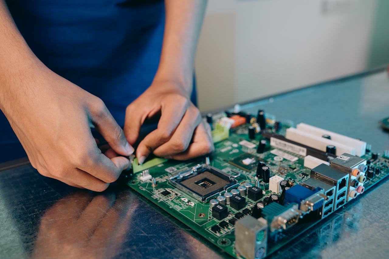 Services-01 Hands-on assembly of a computer motherboard with precision tools.